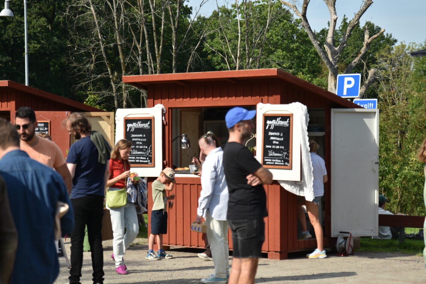Besökare utanför en mat och dryckesbod på marknad