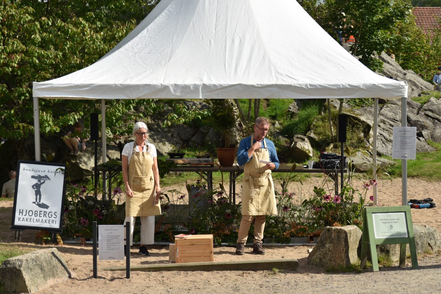 Människor står under utställartält